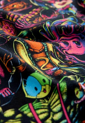 Tessuto nero con motivi colorati in stile cartone animato che raffigurano vari personaggi e forme, mostrando tonalità vivaci e una superficie liscia.