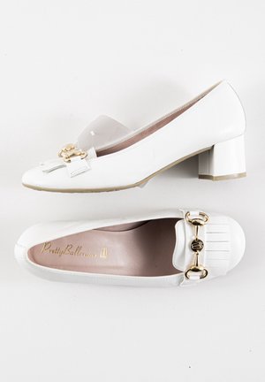 Hvide læder sko med blokhæle og rund tå, med guldfarvet hardwareaccent og frynse detaljer på forsiden.