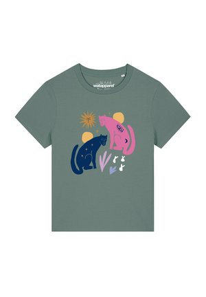 T-shirt vert à manches courtes avec un graphisme de deux chats stylisés, un rose et un bleu, entourés de soleil, lune, étoiles et formes abstraites.