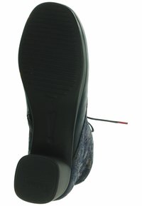 Suola in gomma nera con grip testurizzato, tomaia a motivi blu scuro e dettagli delle stringhe. Design con tacco piatto e punta arrotondata.
