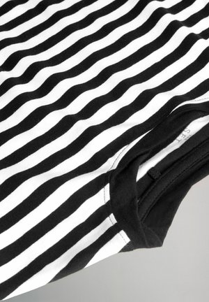 Sort-hvid stribet T-shirt lavet af bomuld. Har bølgede striber, rund halsudskæring og en sort ærmekant. Blød tekstur.