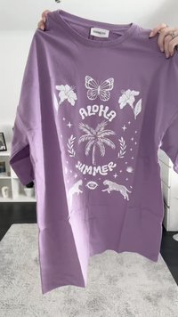 Lila Baumwoll-T-Shirt mit kurzen Ärmeln, versehen mit weißen, tropischen Grafiken: Schmetterlinge, ein Palmenbaum, Leoparden und dem Text "Aloha Sommer".