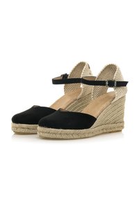 Sandalias de cuña de ante negro con tacón de yute trenzado, tira en el tobillo y parte trasera abierta, con punta redonda y interior texturizado.
