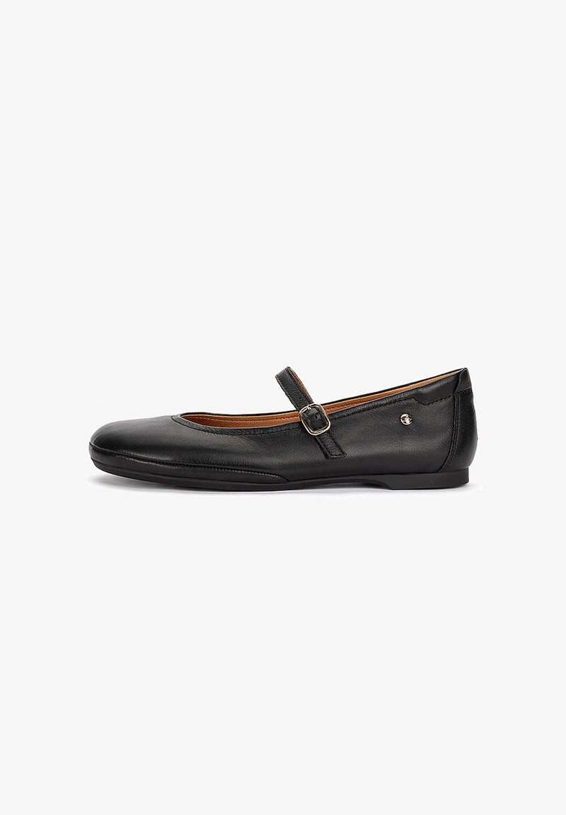 Chaussure plate Mary Jane en cuir noir, avec un bout arrondi, une bride réglable à boucle et un petit logo métallique sur le côté, sur fond blanc.