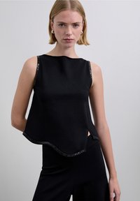 Top negro sin mangas con dobladillo ligeramente curvado, con detalles de lentejuelas a lo largo del escote y las sisas, confeccionado en tela suave.