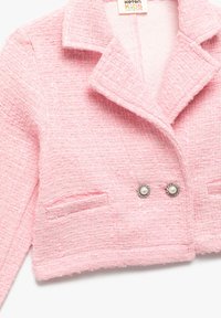 Lyserød tweed cropped jakke med et struktureret mønster, med notch-krave og dobbelte perleknapper. Har diskrete sidelommer.