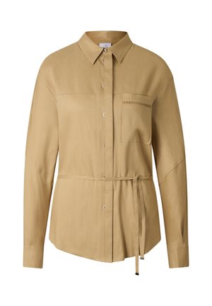 Langærmet beige skjorte med knapper foran, enkelt brystlomme, spids krave og bælte i taljen, med diskrete syninger på ærmerne.