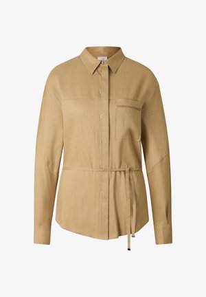 Langærmet beige skjorte med knapper foran, enkelt brystlomme, spids krave og bælte i taljen, med diskrete syninger på ærmerne.