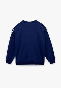 Sudadera azul marino de manga larga, con cuello redondo y puños acanalados. Presenta detalles blancos en las costuras de los hombros. Textura de tejido suave.