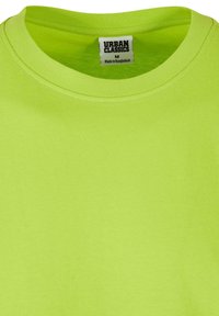 T-shirt a maniche corte, collo rotondo, in cotone di un brillante verde lime. Presenta un'etichetta con la scritta "Urban Classics", taglia M, con una texture liscia.
