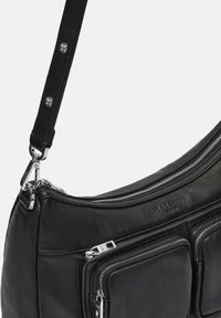 Borsa a spalla in pelle nera con design curvo, diverse tasche con zip e una tracolla testurizzata con dettagli in metallo.