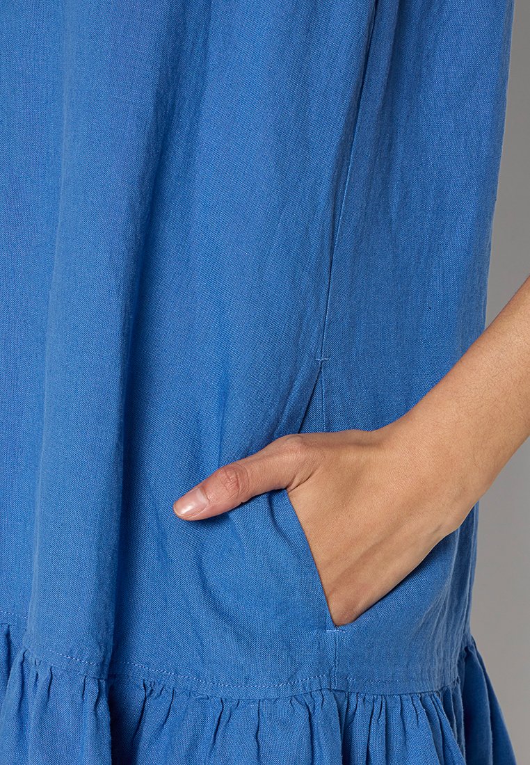 Niebieska bawełniana sukienka o teksturowanym wykończeniu, z boczną kieszenią i marszczonym dołem dla dodatkowego akcentu. Prosty fason, krótki rękaw.