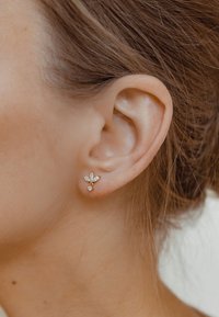 Gold-tone earrings with a floral design featuring two marquise-cut clear gemstones and a round gemstone accent, set in a textured finish.