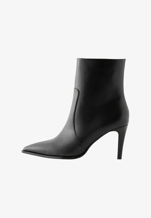 Mustud nahkkinga, millel on teravnina, sile tekstuur ja stiletto konts. Minimalistlik disain, ilma kaunistusteta.