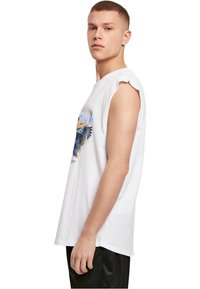 Weißes ärmelloses T-Shirt mit einem bunten Adler-Design auf der Vorderseite. Lockere Passform mit subtilen Ausschnitten an den Schultern, aus weichem Baumwollstoff gefertigt.