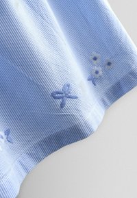 Šviesiai mėlynos spalvos dryžuota audinys su siuvinėtų gėlių ir drugelių motyvais. Minkštas tekstūra su išlenktu apdirbimu.