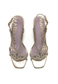 Sandalias doradas con tiras finas y un intrincado diseño de cuentas, punta cuadrada y un bajo tacón de bloque. La plantilla suave en color púrpura presenta el logo "MARIAMARE".