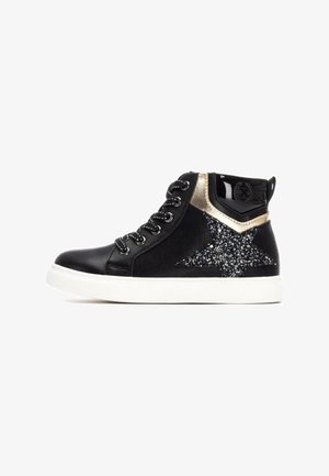 Zapatilla alta negra con un acabado de charol negro brillante, acentos metálicos dorados y un detalle de estrella brillante en el costado. Suela de goma.