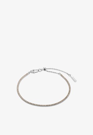 Sart armbånd i sølvtoner med små lysebrune sten, lås med hummerklolukning, justerbar kæde og rektangulært mærke med mærkenavn.