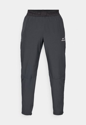 Nike Pro bukser i mørkegrå, med en sort elastisk talje med teksten "PRD" og "NIKE PRO", glat stof, tætsiddende design og subtile syninger.