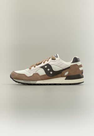 Hvid og brun lav top sneaker med mesh og ruskind paneler, brune snørebånd og sort logo på siden, vist fra ydersiden.