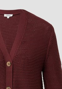 Cárdigan de punto burdeos con cuello en V, que presenta un patrón texturizado y tres botones marrones en la parte delantera para el cierre.