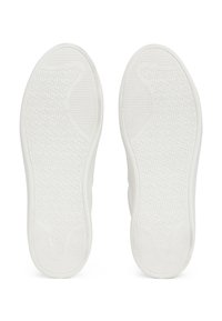 Deux semelles de chaussures blanches avec des motifs de bande de roulement texturés, plates et symétriques, vues du dessous sur fond blanc.