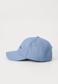 Blauwe katoenen baseballpet met een gebogen klep, voorzien van een geborduurd logo aan de voorkant en luchtgaatjes voor ventilatie.