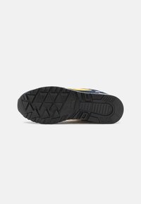 Black rubber sneaker sole with a traction pattern. Features a textured surface and reinforced heel, showcasing a sturdy design.