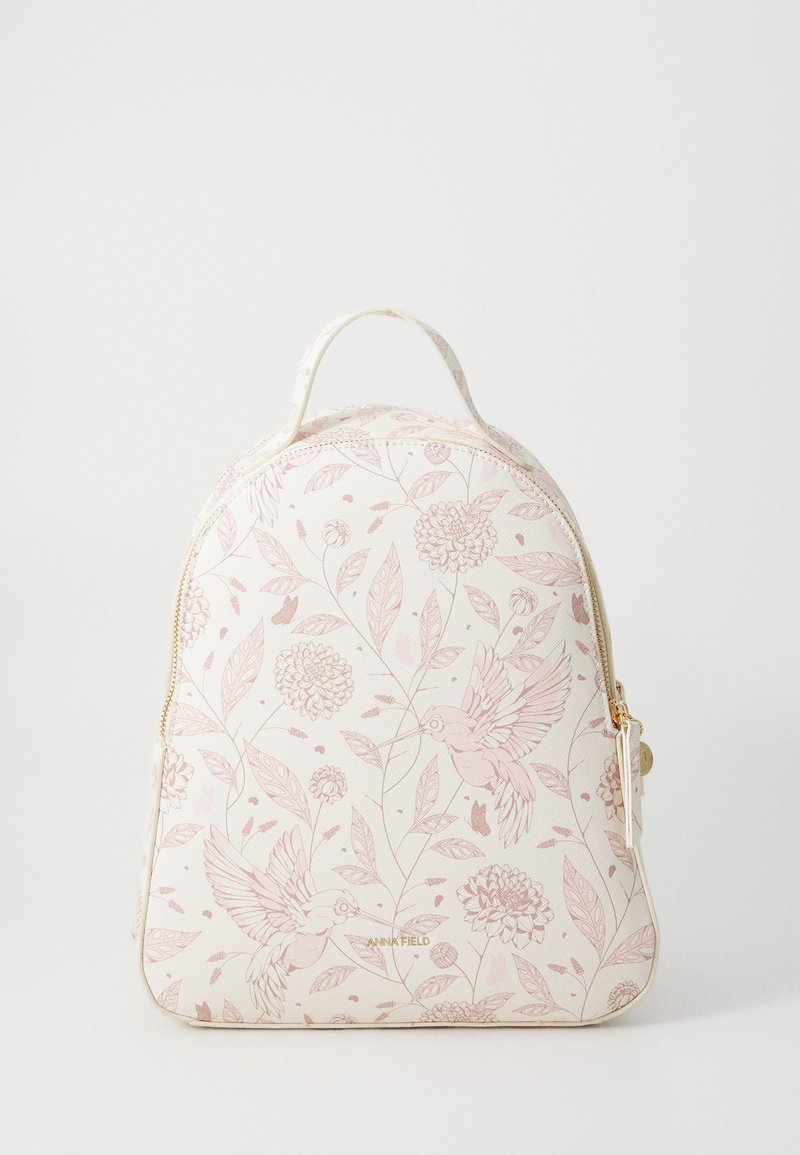 Zaino crema con motivo floreale rosa, caratterizzato da un design curvo, manico superiore e zip dorata. Tessuto texturizzato con motivi naturali.