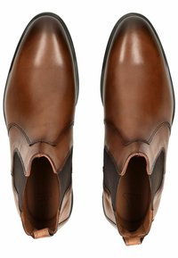 Braune Leder-Ankle-Boots mit elastischen Seiteneinsätzen, spitzer Zehenform, glatter Oberfläche und minimaler Nahtverarbeitung. Akzentuiert mit einer Zuglasche.