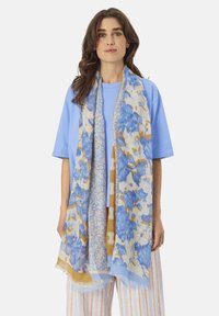 Lightweight scarf featuring an abstract floral pattern in blue and gold tones. Edges are fringed, fabric has a soft texture.