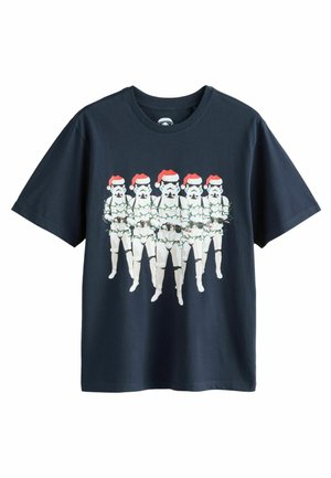 Musta puuvillapaita, jossa on kuvitus kuudesta stormtrooperista jouluhatuissa, kietoutuneena joulukoristevaloihin, ja pyöreä pääntie.