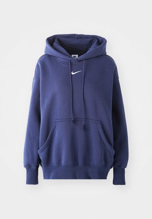 Jūras spēku zilas krāsas kapučjaka, izgatavota no mīksta kokvilnas sajaukuma, ar priekšējo kabatu, aizsietu kapuci un balto Nike logo uz krūtīm.