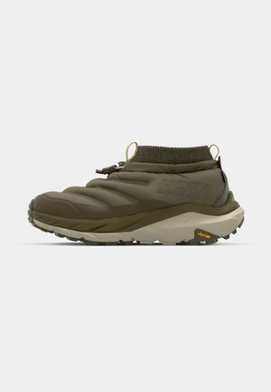 Alyvuogių žalia, pūkuoti žemi batai su megztu apvadu, reguliuojamu užtrauktuku ir Vibram padu traukimui. Lengvas, sportiškas dizainas.