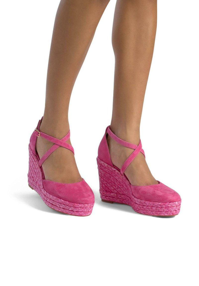 Scarpe con tacco wedge in suede rosa con cinturini incrociati alla caviglia, caratterizzate da una base in stile espadrilles intrecciata e testurizzata e design a punta tonda.