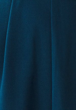 Turkizna tkanina z mehko, gladko teksturo, ki ima rahlo sijaj. Material se elegantno spušča z diskretnimi gubami. Brez vidnih vzorcev ali kovinskih delov.