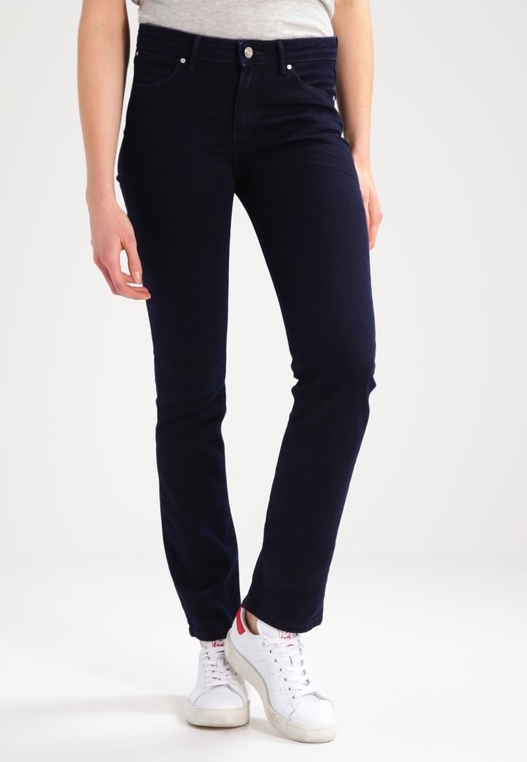 Mörkblå, stretchiga denimjeans med slim fit, fem fickor, bälteshällor och silverdetaljer. Matchas med vita sneakers.