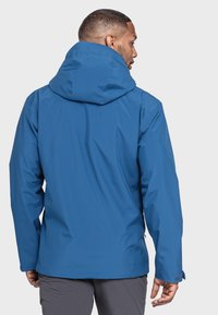Blauem wasserdichtem Jacket mit Kapuze, glatter Textur und verstellbaren Manschetten. Hat einen geraden Schnitt und eine versteckte Reißverschlusstasche an der Seite.