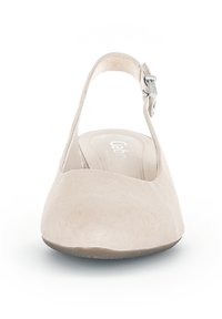 Scarpa pianeggiante beige in suede, con punta tonda, cinturino alla caviglia e un'aggiunta di fibbia argentata. Texture liscia, design minimalista.