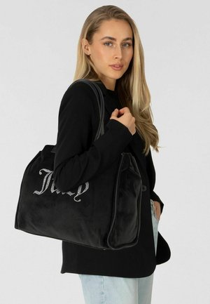 Schwarze Handtasche aus Wildleder mit weicher Textur, verziert mit silbernen Strasssteinen in Kursivschrift. Doppelter Schulterriemen und Reißverschluss.