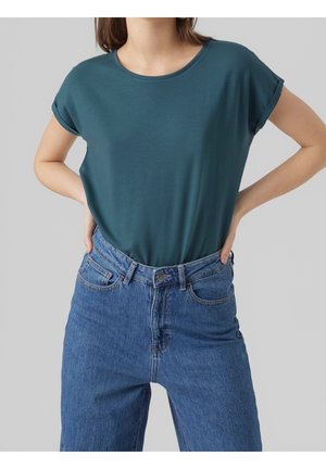 Krótki t-shirt w kolorze morskim z okrągłym dekoltem, zestawiony z niebieskimi dżinsami o wysokim stanie, posiadającymi klasyczny fason z pięcioma kieszeniami.