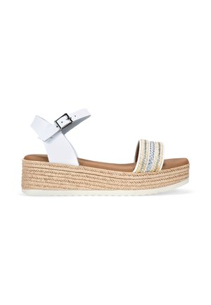 Sandalia cuña blanca con una suela texturizada estilo espadrille, que presenta tres bandas horizontales con acentos plateados y una correa en el tobillo con un cierre de hebilla.