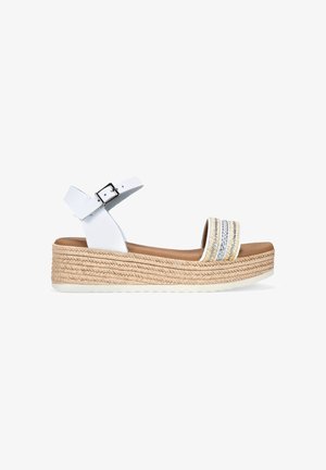 Sandalia cuña blanca con una suela texturizada estilo espadrille, que presenta tres bandas horizontales con acentos plateados y una correa en el tobillo con un cierre de hebilla.