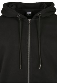 Sudadera con cremallera negra, confeccionada en una mezcla de algodón, con capucha ajustable, cremallera de metal y puños acanalados para un ajuste seguro.