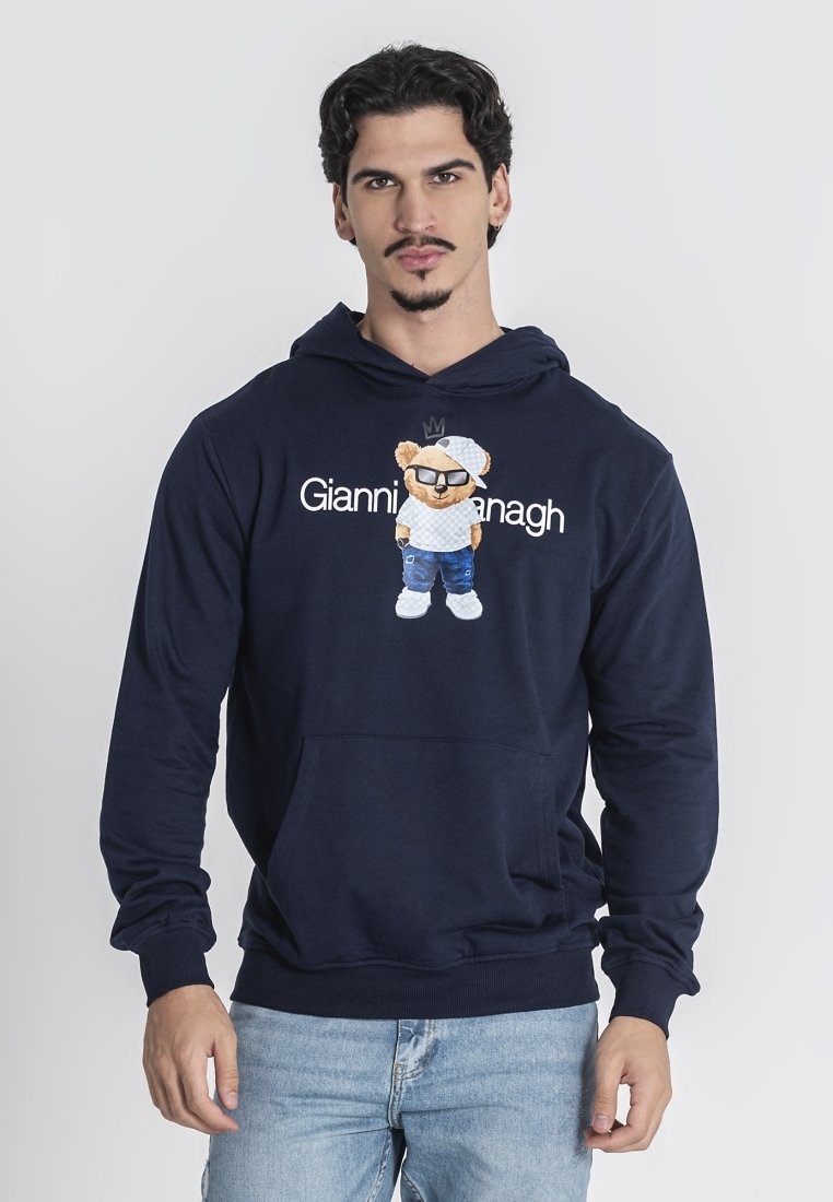 Námořnická modrá mikina vyrobená z měkké látky, s grafikou medvěda v slunečních brýlích, pod kterou je vytištěn text "Gianni Hanagh". Elastické manžety.