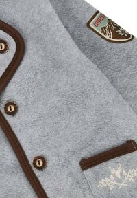 Graue Fleece-Jacke mit braunen Akzenten, Druckknopfverschluss, Brusttasche mit gestickten Details und einem Abzeichen an der Schulter.