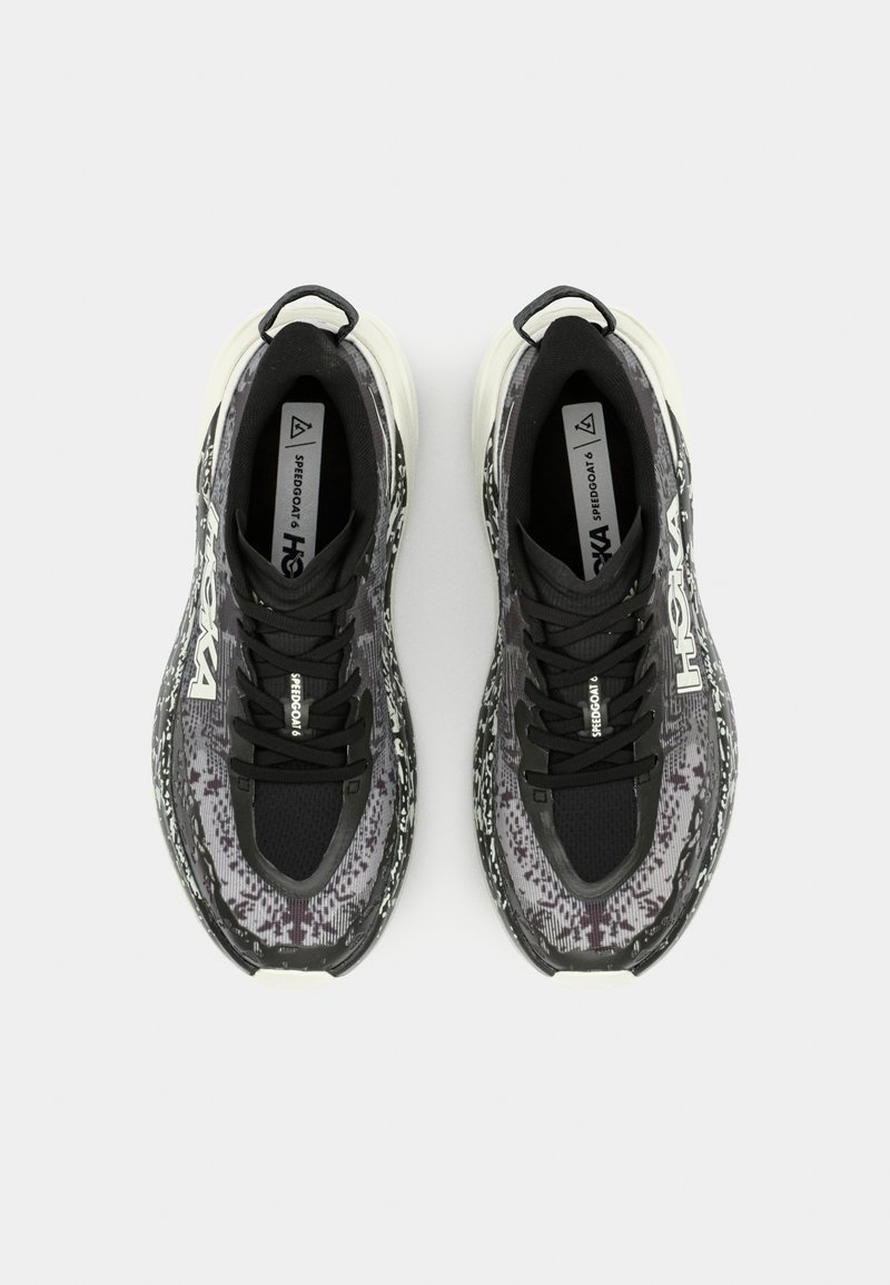 Czarno-szare wzorzyste buty sportowe z siateczkową cholewką, grubą białą podeszwą środkową i czarnymi sznurowadłami. Zawierają logo oraz pętle przy piętach.
