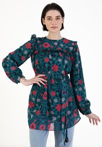 Kwiatowa bluzka w kolorze teal, zdobiona wzorami w odcieniach czerwieni, różu i czerni. Fala na dekolcie oraz długie rękawy z wiązaniem w talii. Lekki materiał.
