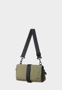 Borsa a tracolla verde in tessuto con una tracolla nera; presenta una forma cilindrica, design elegante, accento con fibbia frontale e tracolla regolabile.